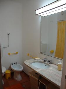 a bathroom with a sink and a toilet and a mirror at Apartamento Ariadna in Albufeira
