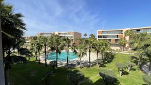 uma vista aérea de um resort com uma piscina e palmeiras em Herdade dos Salgados, T2 12C 3D, Vila das Lagoas em Albufeira