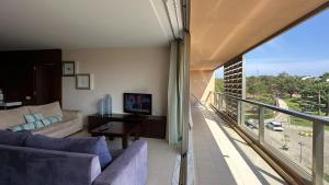 a living room with a couch and a balcony at Herdade dos Salgados, T2 12C 3D, Vila das Lagoas in Albufeira