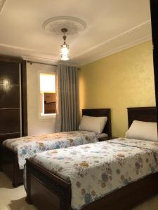 une chambre avec deux lits et une fenêtre dans l'établissement Résidence Hôtelière El Marraki, à Nador