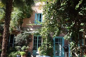 une maison rose avec des fenêtres et des arbres bleus dans l'établissement "Maison 1850 Paris 18" Chambre G avec terrasse et parking en option, à Paris