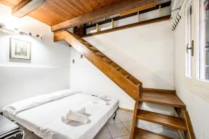 sypialnia z łóżkiem na podwyższeniu i schodami w obiekcie Piazza Maggiore - Central Loft con Patio w Bolonii