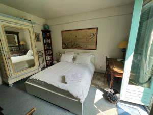 a bedroom with a bed and a desk and a mirror at "Maison 1850 Paris 18" Chambre G avec terrasse et parking en option in Paris +8 photos