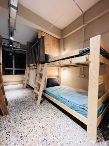 a room with three bunk beds in it at Walk Home Hostel in Chiayi City
