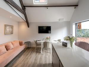 uma cozinha e sala de estar com um sofá e uma mesa em Pass the Keys Dahlia Contemporary town centre apartment em Shrewsbury