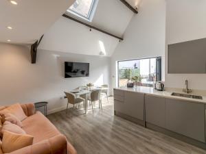 a kitchen and living room with a couch and a table at Pass the Keys Dahlia Contemporary town centre apartment in Shrewsbury