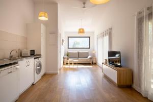 uma cozinha e sala de estar com um sofá e uma televisão em La Caseta em Sant Jaume de Llierca