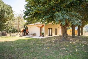 una casa con un árbol en el patio en La Caseta, en Sant Jaume de Llierca