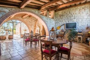 uma sala de jantar com mesas e cadeiras e uma parede de pedra em Appartamento il Pino em Rapolano Terme