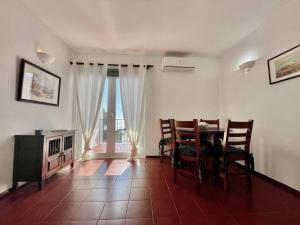 d'une salle à manger avec une table, des chaises et une fenêtre. dans l'établissement 1bedroom duplex beach apartment, à Carvoeiro