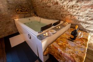 a bath tub with a table and a bottle of wine at Castello Valenzino in Umbertide