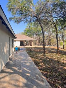 a person walking down a sidewalk next to a building at Mbuluzi Game Reserve in Simunye