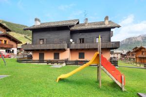 a playground with a slide in front of a house at Residence Valleverde in Livigno