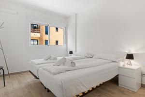 1 dormitorio blanco con 2 camas y ventana en Perla apartment near Fuengirola harbour - Ref 239, en Fuengirola