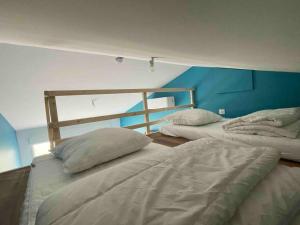two beds in a room with a blue wall at Charmant Studio - Jacuzzi/Jardin in Andernos-les-Bains