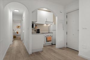 a kitchen with white cabinets and an archway at Los Boliches comfy retreat - Ref 229 in Las Lagunas Mijas