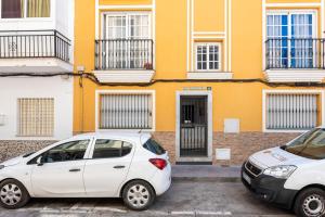 due auto parcheggiate di fronte a un edificio giallo di Los Boliches comfy retreat - Ref 229 a Las Lagunas Mijas