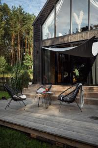 dwa krzesła i stół na drewnianym tarasie w obiekcie Domki Momenty w mieście Słajszewo