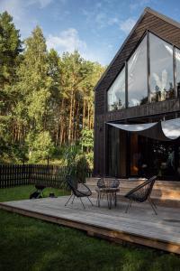 a house with two chairs and a table on a deck at Domki Momenty in Słajszewo