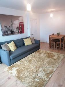 a living room with a blue couch and a table at Self contained 2 Bedroom flat in Southwark in London