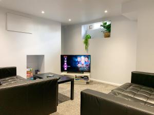 a living room with two couches and a flat screen tv at Stylish 3-bedroom home in Canterbury City-Centre - Superb Location! in Canterbury