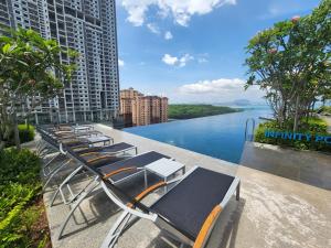 a row of chaise lounge chairs overlooking a river at Urban Suite - George Town in Jelutong