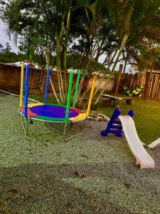 einen Spielplatz mit Rutsche und Spiel in der Unterkunft Container Suítes Recanto Monte Trigo in São Francisco do Sul