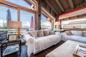 a living room with a white couch and a large window at Chalet Purdey Combloux - BY EMERALD STAY in Combloux