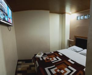 Habitación de hotel con cama y TV de pantalla plana. en Hotel la guaneña, en Ipiales
