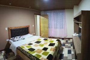 1 dormitorio con 1 cama con edredón en Hotel la guaneña, en Ipiales