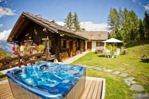 a hot tub in front of a log house at Chaletbethere in Pila