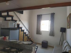a living room with a couch and a tv and stairs at Recanto Trevo da Pampulha in Belo Horizonte