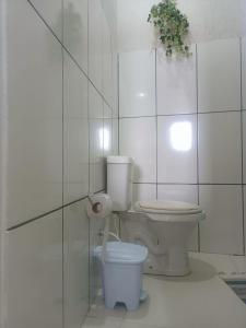 a white bathroom with a toilet and a plant at Recanto Trevo da Pampulha in Belo Horizonte