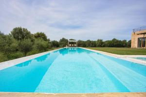 une grande piscine d'eau bleue dans l'établissement Finca Son Coranta, à Campos