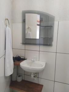 La salle de bains est pourvue d'un lavabo et d'un miroir. dans l'établissement Recanto Trevo da Pampulha, à Belo Horizonte