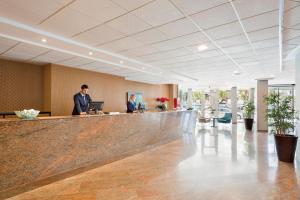 two people standing at a bar in a lobby at Hotel Best Negresco in Salou