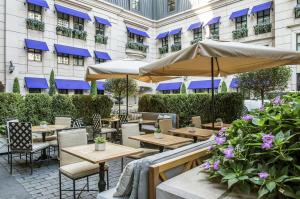 a patio with tables and umbrellas in front of a building at Waldorf Astoria Chicago in Chicago