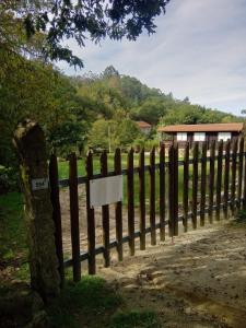 una valla con un letrero al costado de una carretera en Refugio do Lentinho, en Entre Ambos os Rios