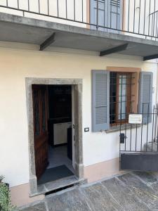 une porte menant à une maison dotée d'un balcon et d'un escalier. dans l'établissement Casa Albina, à Craveggia