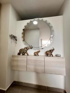 een spiegel boven een dressoir in een badkamer bij AlOJAMIENTO EN BELLO in Bello