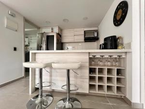 a kitchen with two bar stools and a clock on the wall at AlOJAMIENTO EN BELLO in Bello