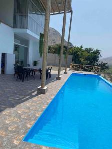 a large blue swimming pool next to a house at Mirador del Paraiso in Lunahuaná