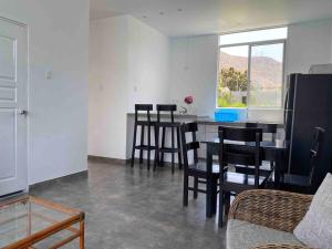 a kitchen with a table and chairs in a room at Mirador del Paraiso in Lunahuaná