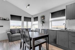 a kitchen and dining room with a table and chairs at Selfoss Modern Cabins in Selfoss