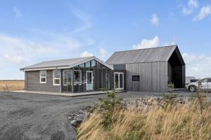 uma pequena casa com um telhado preto e janelas em Selfoss Modern Cabins em Selfoss