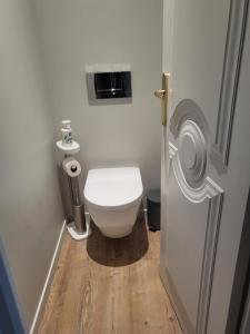 a small bathroom with a toilet and a wooden floor at La Petite Perle de Quimper in Quimper
