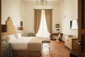a bedroom with a bed and a desk and a window at Casa Pizarro Hotel in Cáceres