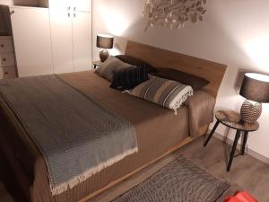ナポリにあるCasina San Gregorio Apartmentのベッドルーム1室(大型ベッド1台、ランプ2つ、椅子付)