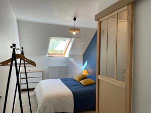 een slaapkamer met een bed met blauwe lakens en een raam bij Maison L'Aiguille - 2 appartements, 5 chambres et table d'hôtes au pied de la montagne à la station de Laye in Laye