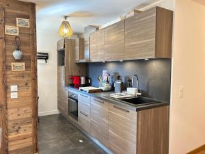 a kitchen with wooden cabinets and a sink at Appartement Les Gets, 3 pièces, 6 personnes - FR-1-623-116 in Les Gets